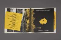Open record jacket on top of a grey background. The inside is black and yellow, with the left side reminiscent of a wood pattern. The right side is black with a yellow shape in the middle. There is a yellow block with some black text on the left side. And white text at the bottom and the top of the right side.