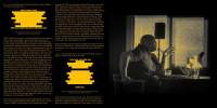Yellow text on top of a black background. The text appears on the left side in two columns, with two sections of text appearing redacted in yellow. A photograph, also in black and yellow, occupies the right side. It depicts a person sitting at a desk. They are are holding the back of the chair with their right hand and gesticulating with their left hand, keeping their left elbow on the table.