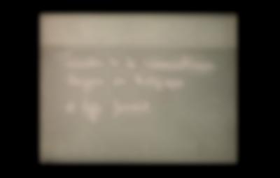 On top of a grey background, possibly a wall, the following text has been handwritten: 