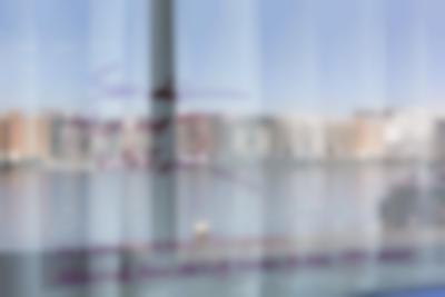A reflection on a glass surface shows a river and buildings on the opposite bank. In purple text, the following text appears: 
