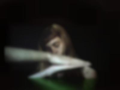 A large screen shows the image of a person with a short fringe and long straight hair. They are leaning to the left and have their eyes closed. In front of them, held horizontally, two palms are held against each other.