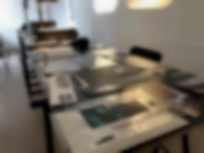 Table seen from above. Laid on the table are several photographs and other printed material.