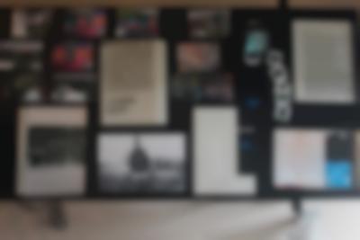Table seen from above. Laid on the table are several photographs, printed texts, booklets and a few old photo slides.