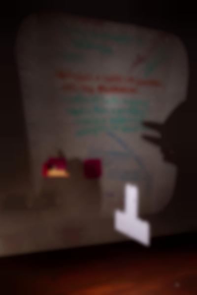 A transparency sheet with handwritten notes is being projected on a tiled wall. The larger sentence, in red, reads: 